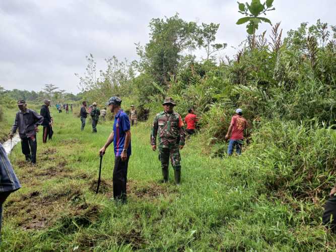 Babinsa Tembilahan Hilir Laksanakan Gotong Royong di TPU Darussalam Jelang Ramadan