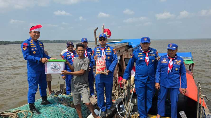 Satpol Airud Polres Pelalawan Bagikan Bendera Merah Putih dan Bansos Kepada Nelayan di Perairan Kuala Kampar