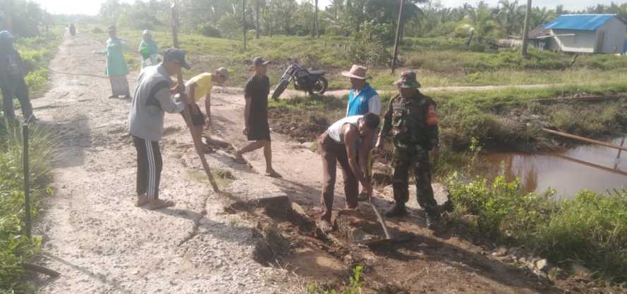 Sertu Wisnu Hartono Perbaiki Jalan Poros Desa Bersama Masyarakat