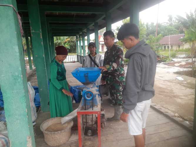 Latih Warga Sertu Suherman Ajarkan Warga Cara Menggunakan Mesin Pengering Beras