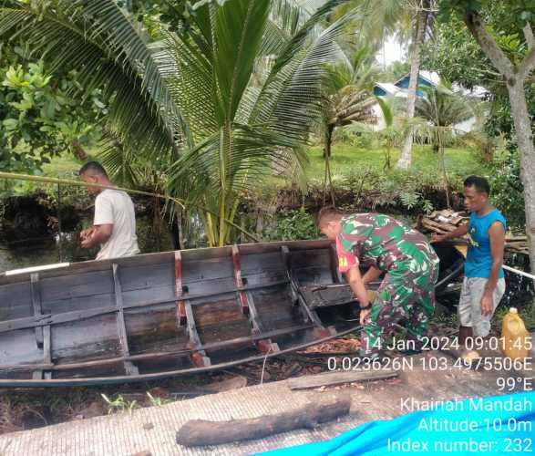 Babinsa Membantu Para Nelayan Membenahi Perahu Sebelum Turun Ke Laut