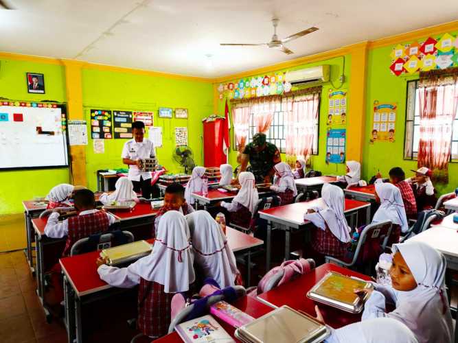 Babinsa Serda Miskal Dampingi Penyaluran 5.528 Porsi Makanan Bergizi Kepada Para Pelajar