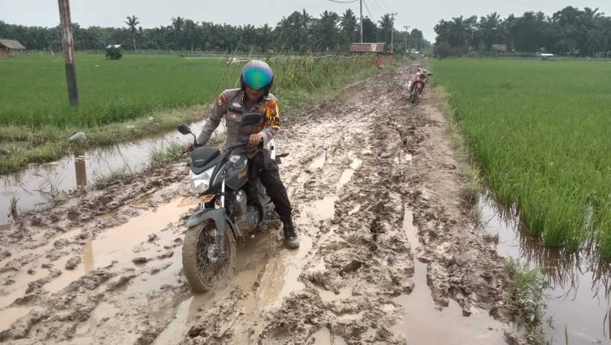 Tempuh Jalan Berlumpur dan Licin, Polsek Kempas Terus Sampaikan Pesan Pemilu Damai.