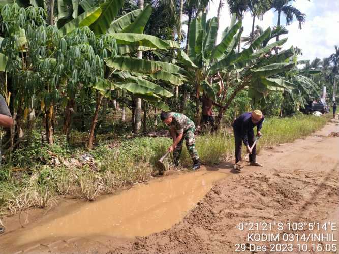 Timbun Jalan Berlubang yang  digenangi Air,Babinsa Selamatkan Pengguna Jalan