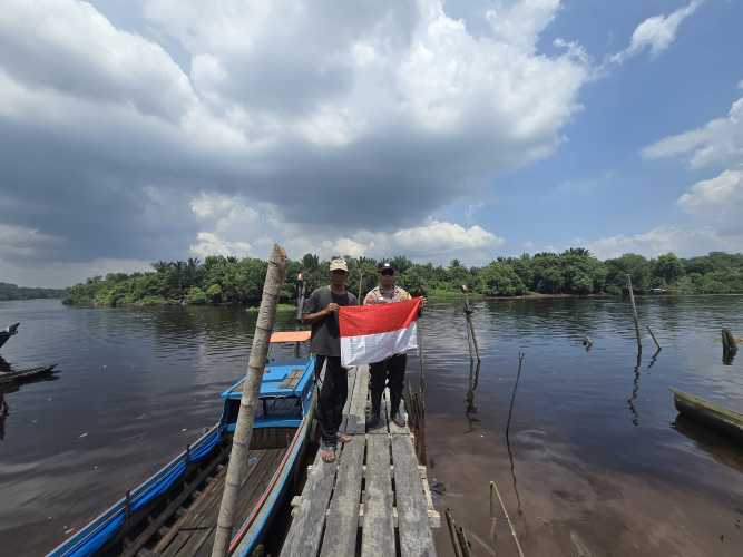 Ekspedisi Presisi Merah Putih, Babinkamtibmas Polsek Pelangiran Bagikan Bendera di Pesisir Tanjung Simpang
