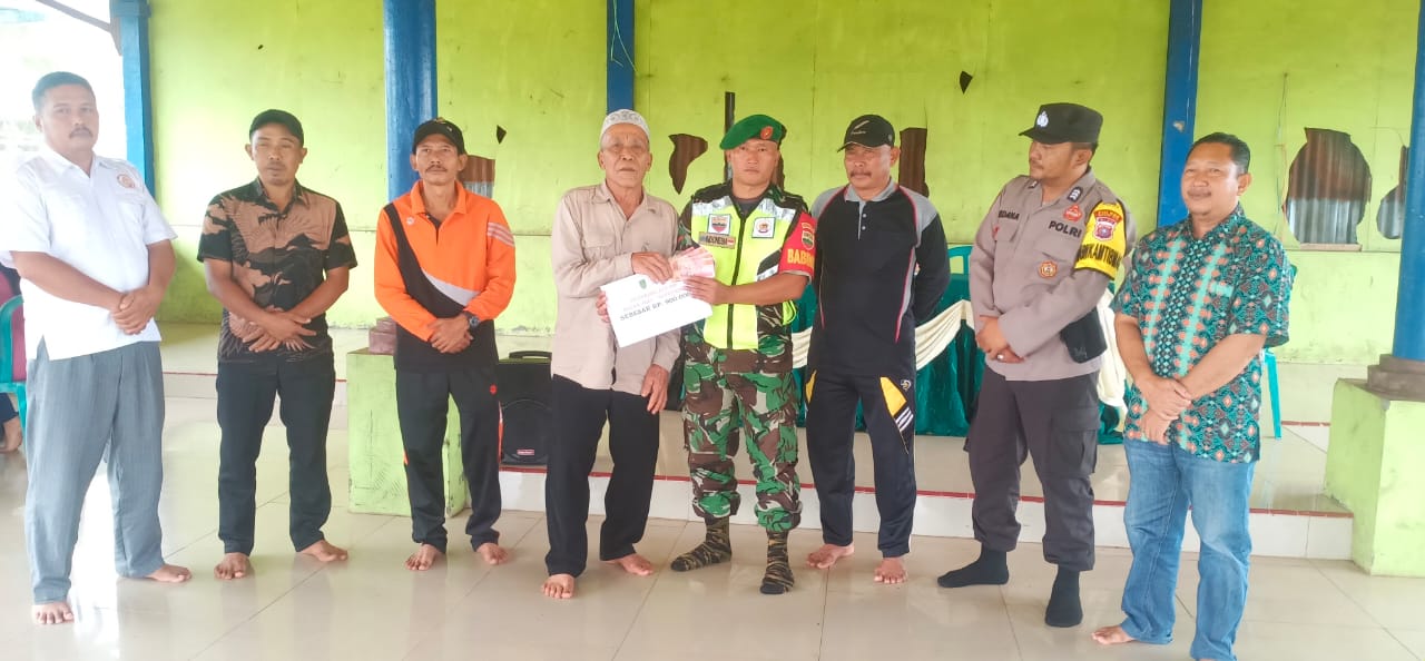 Kopda J.Manurung Babinsa Koramil 10/Pelangiran Salurkan Bansos di Kantor Desa