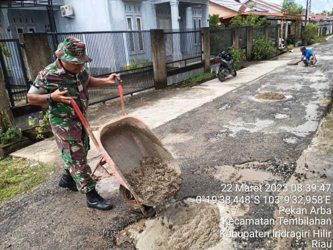 Sertu Anton Bersama sama Warga lakukan Penimbunan Jalan Rusak