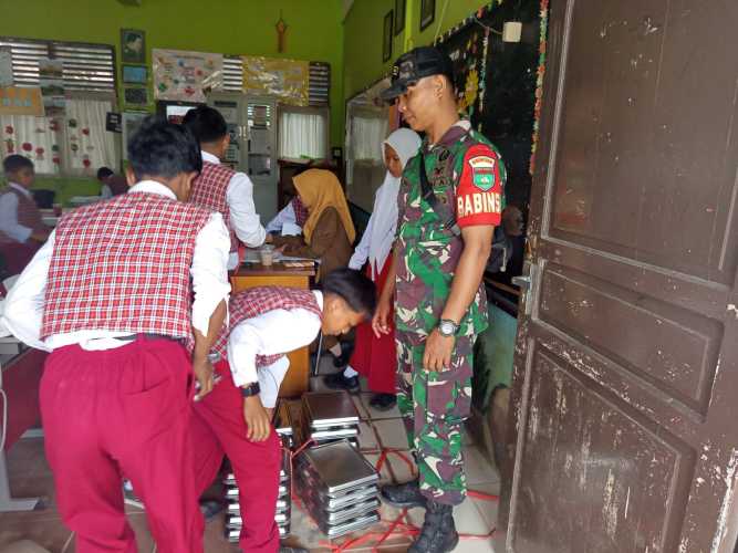 Babinsa Serda Ronal Manalu Bagikan MBG di Sekolah dan Posyandu Tembilahan Hulu