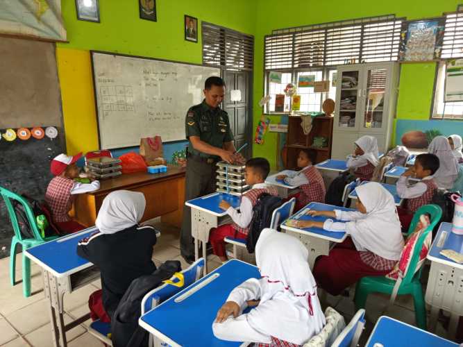 Babinsa Serda Ronal Manalu mendampingi Tim SPPG dalam distribusi 2.863 porsi MBG.