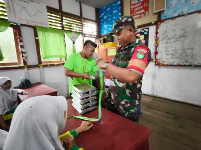 Babinsa Serda Miskal Dampingi Pembagian 3.179 Porsi Makan Bergizi Gratis di Tembilahan Hulu