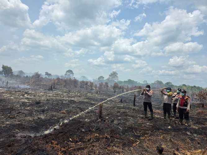Kapolsek Pelangiran Pimpin Pemadaman dan Pendinginan  Titik Api di Desa Simpang Kateman